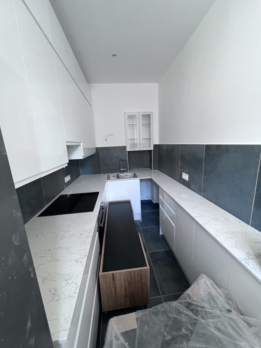 Cuisine d'appartement pendant les finitions, plan de travail posé et meubles en cours d'installation